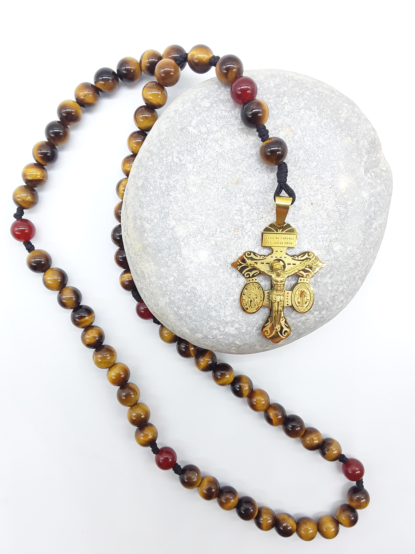 Handcrafted Pocket Catholic Rosary resting on natural stone, made of Tiger’s Eye and Carnelian beads with steel crucifix
