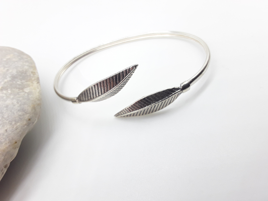 Leaf Form sterling silver cuff bracelet beside stone — Polmadeva