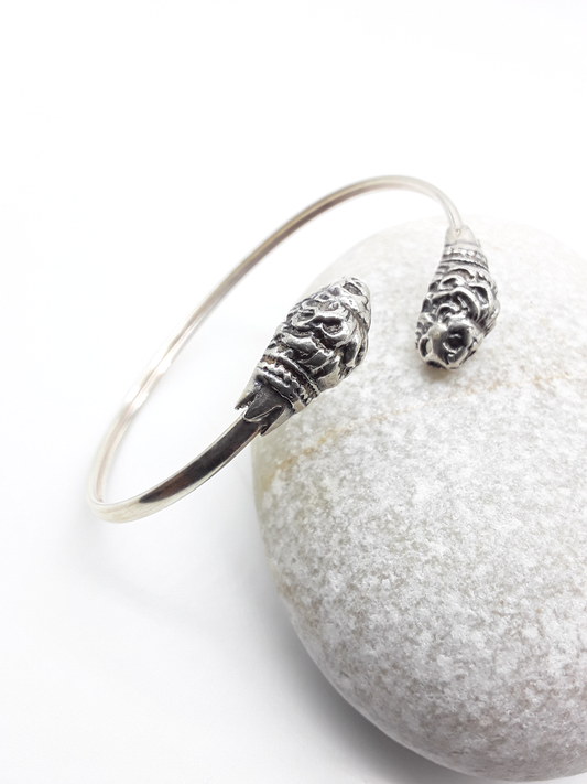 Lion Presence sterling silver cuff bracelet beside stone — Polmadeva