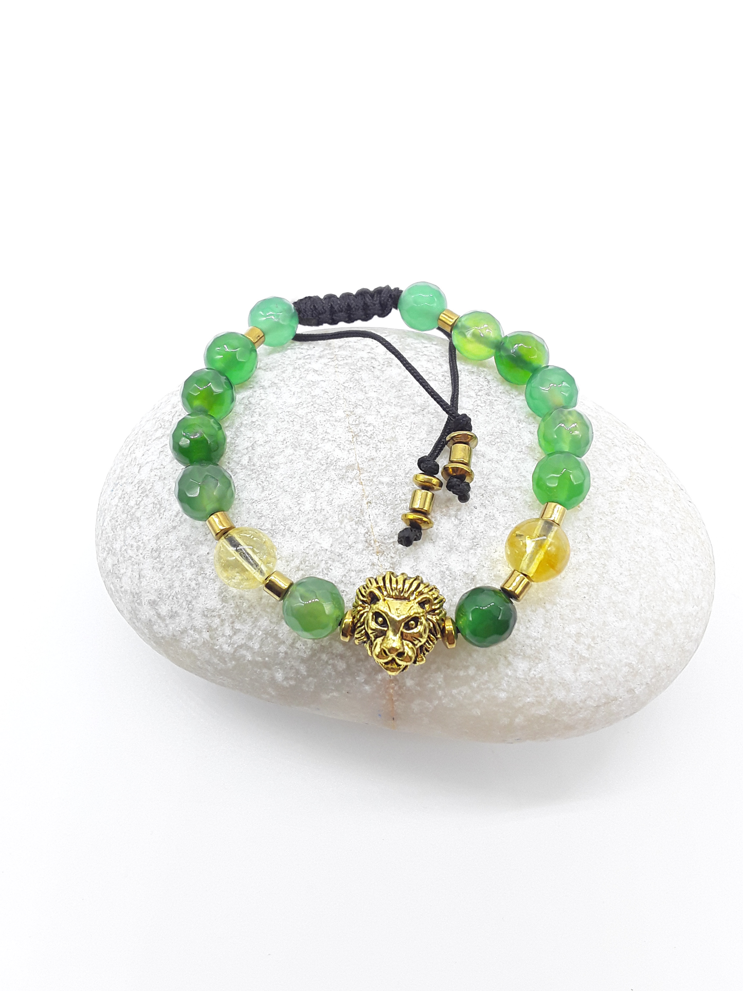 Quiet Ascent Lion Bracelet with citrine and agate beads resting on natural stone, symbol of calm upward movement