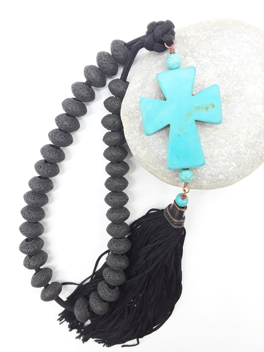 Lava and Howlite Orthodox Paracord Rosary resting on natural stone surface with tassel and cross by Polmadeva.
