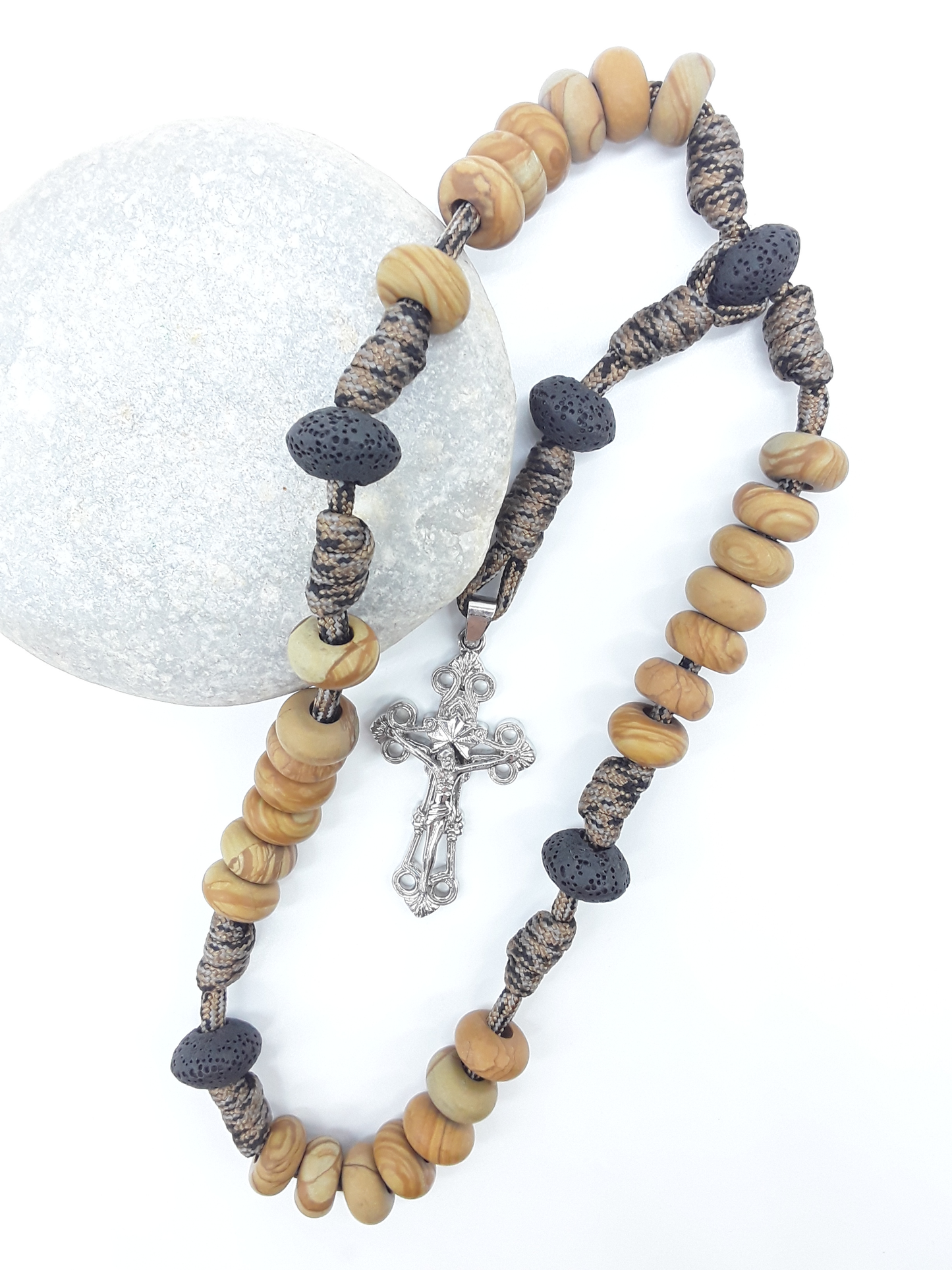 The Grounded Path — Natural Wood and Lava Stone Paracord Anglican Prayer Beads with stainless steel Cross by Polmadeva resting on natural stone.