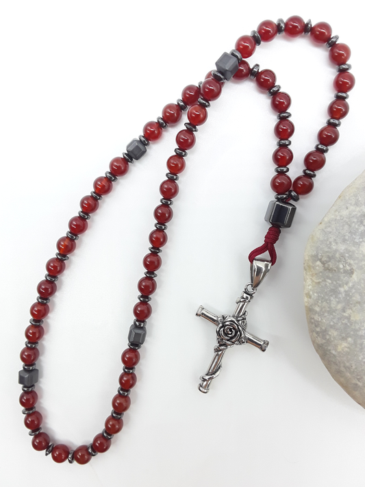 Carnelian and Hematite Orthodox Rosary with stainless steel cross beside natural stone surface by Polmadeva.