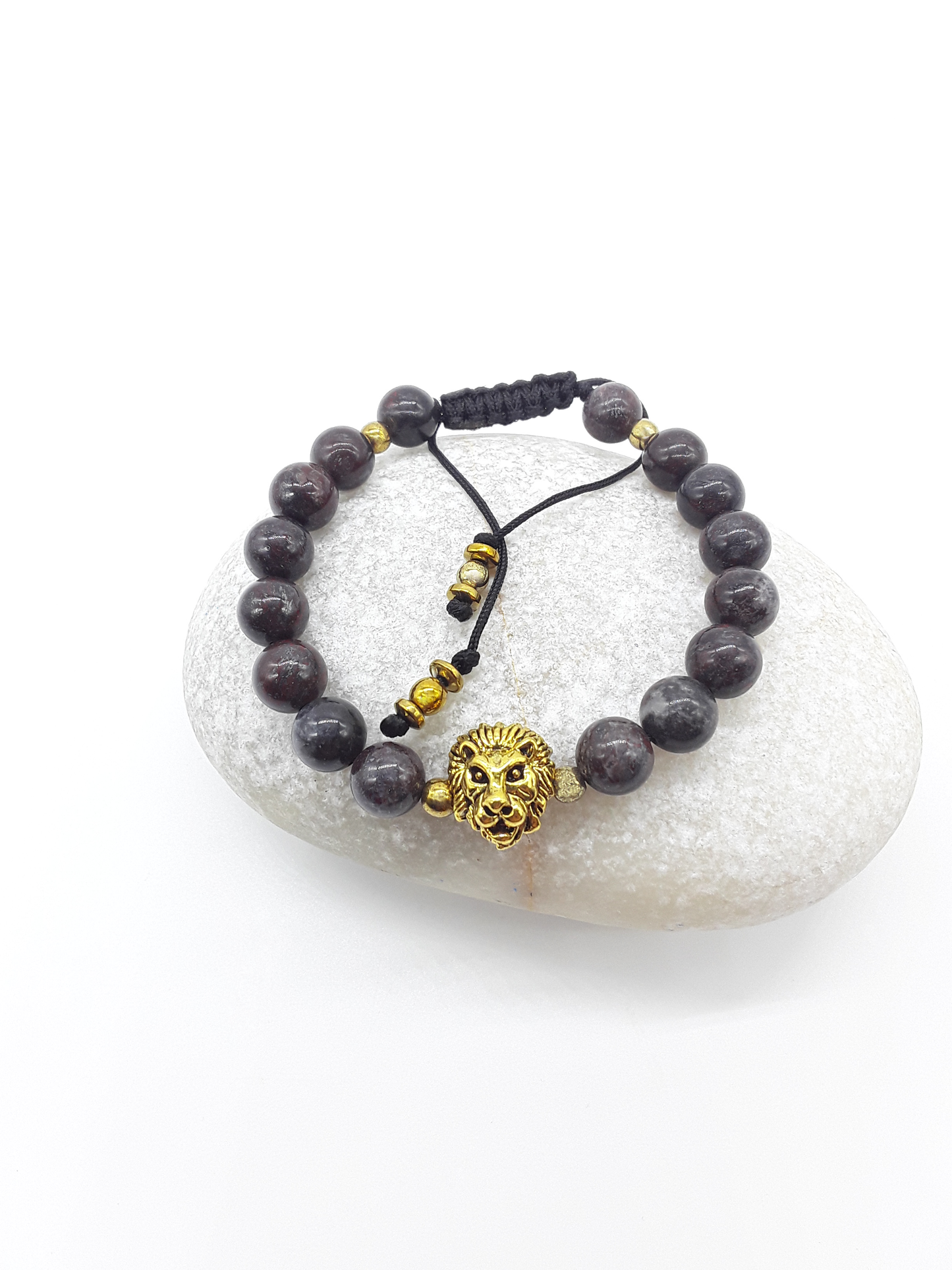 Lion bracelet with natural bloodstone beads resting on stone