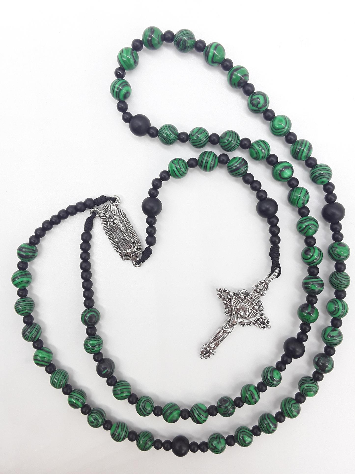 Black onyx and malachite Catholic rosary with Our Lady of Guadalupe centerpiece and a silver-toned crucifix, photographed on a white background.