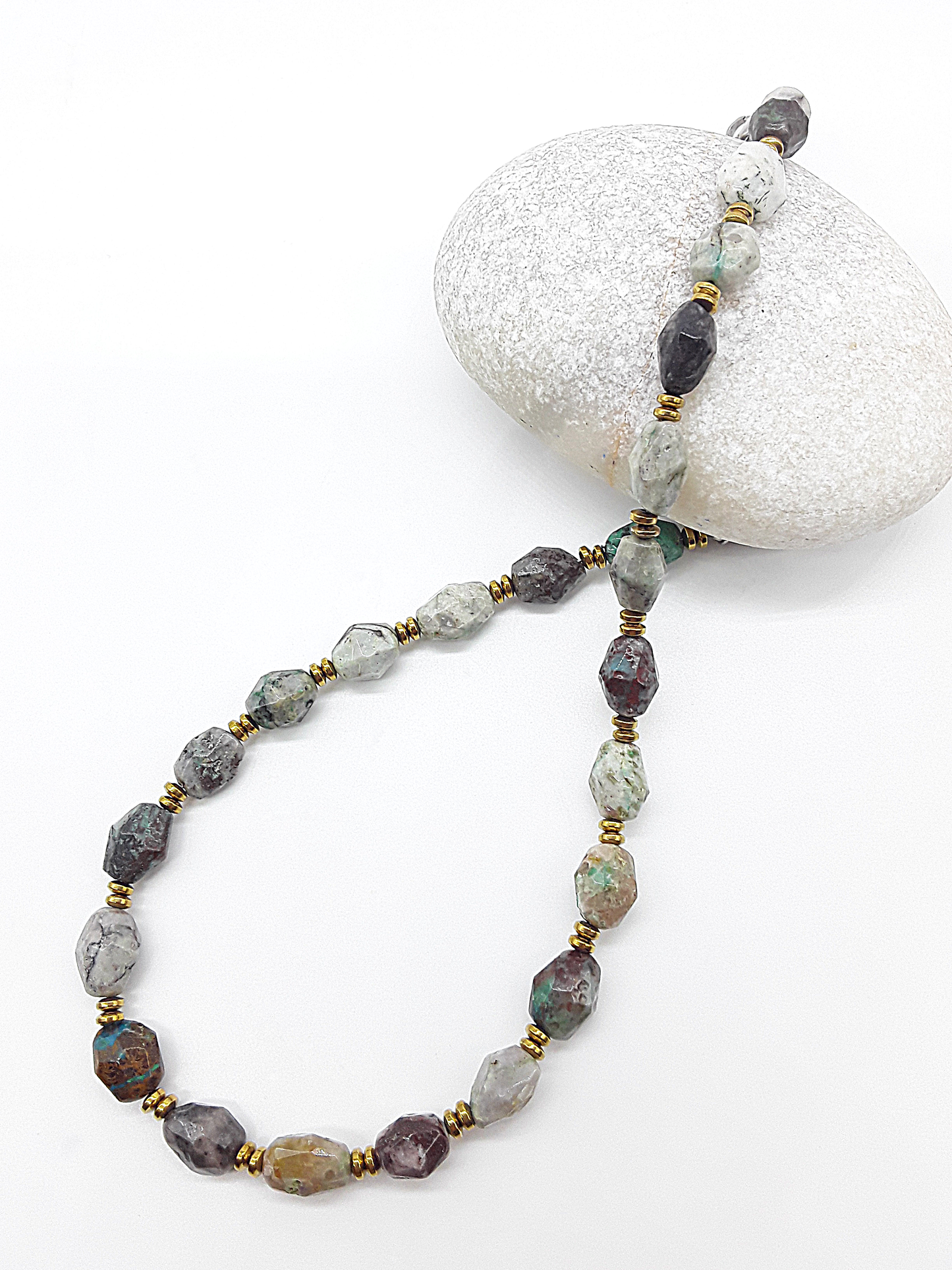 Necklace with multicolored beads on a white stone background