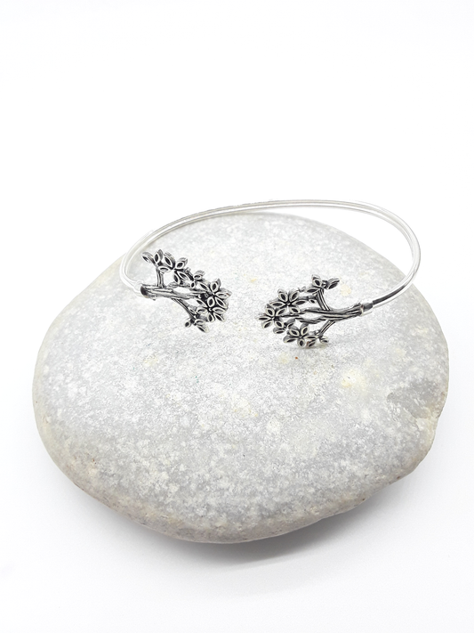 Tree of Presence sterling silver cuff bracelet beside stone — Polmadeva