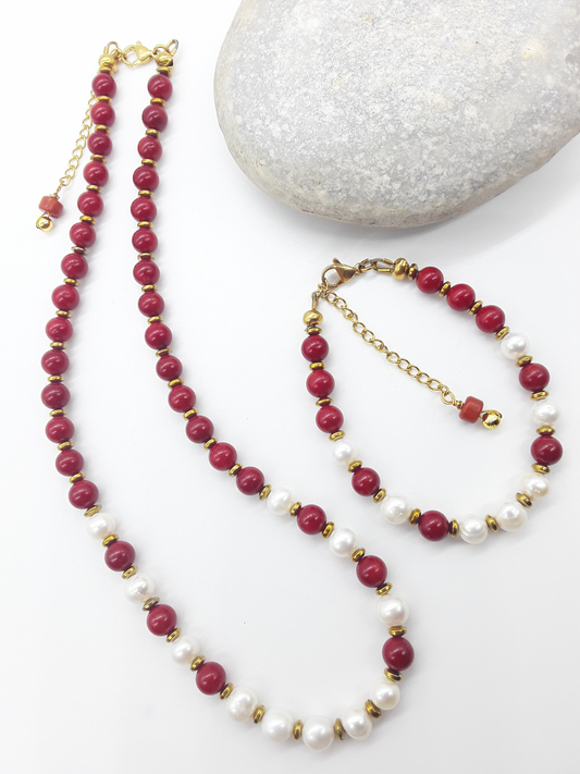 Where Grace Begins coral, freshwater pearl and hematite necklace with matching bracelet displayed beside a natural stone by Polmadeva