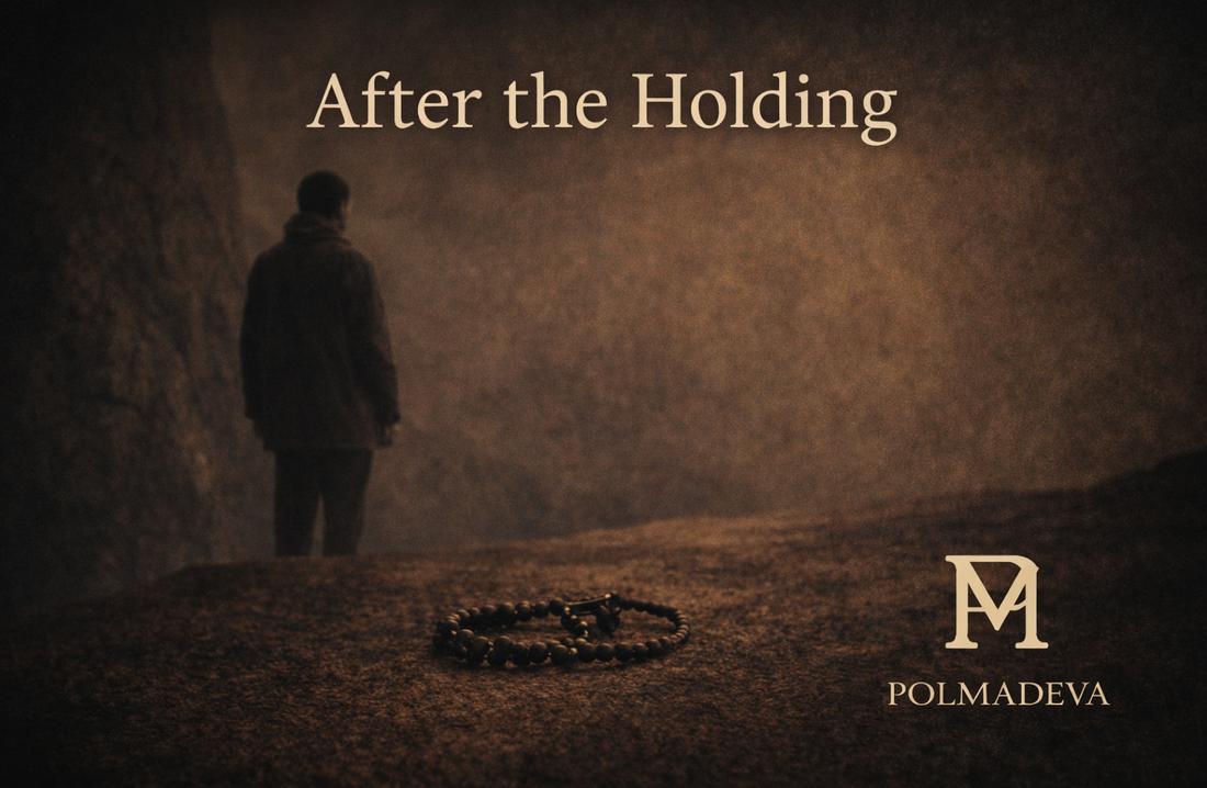 A quiet scene showing a solitary figure and a rosary on the ground, evoking stillness and presence. “After the Holding” title above, POLMADEVA logo at the bottom right.