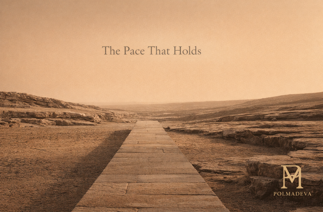 Stone pathway across a quiet desert landscape under warm light, titled “The Pace That Holds,” with the Polmadeva logo in the lower right corner.