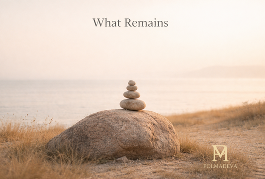 Calm landscape image of balanced stones on a rock near the shoreline, bathed in soft warm light, expressing stillness, clarity, and grounded presence. Polmadeva logo at the bottom right.