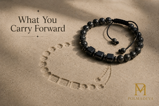 Bracelet resting on a sandy surface with a subtle imprint beneath it, titled “What You Carry Forward”, Polmadeva logo bottom right.
