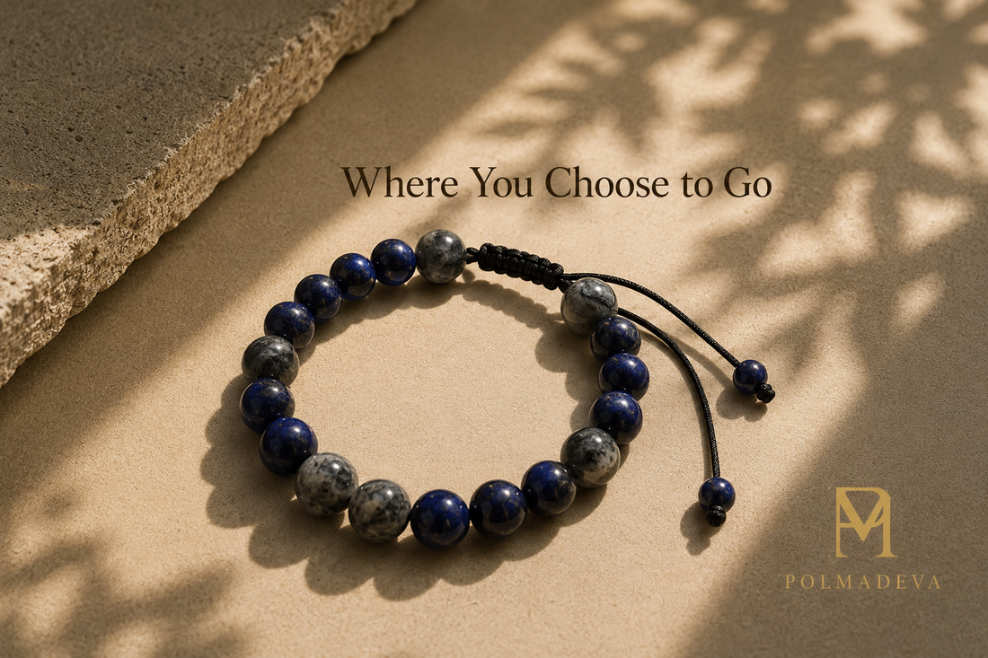 Bracelet in an open circular form on a warm stone surface with soft directional shadows, titled “Where You Choose to Go”, Polmadeva logo bottom right.