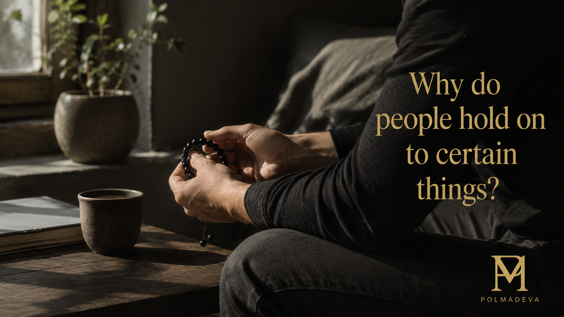 A person sitting indoors holding black beads in their hands, with soft natural light and a calm everyday moment, reflecting on meaningful objects.