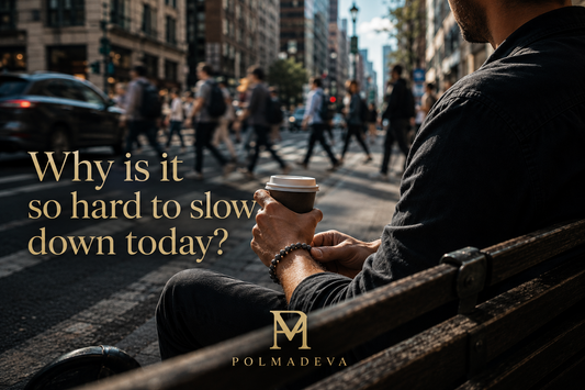 A busy city street with people and traffic in motion, while a person sits on a bench holding a coffee and touching a bracelet, with the text “Why is it so hard to slow down today?” and the Polmadeva logo.