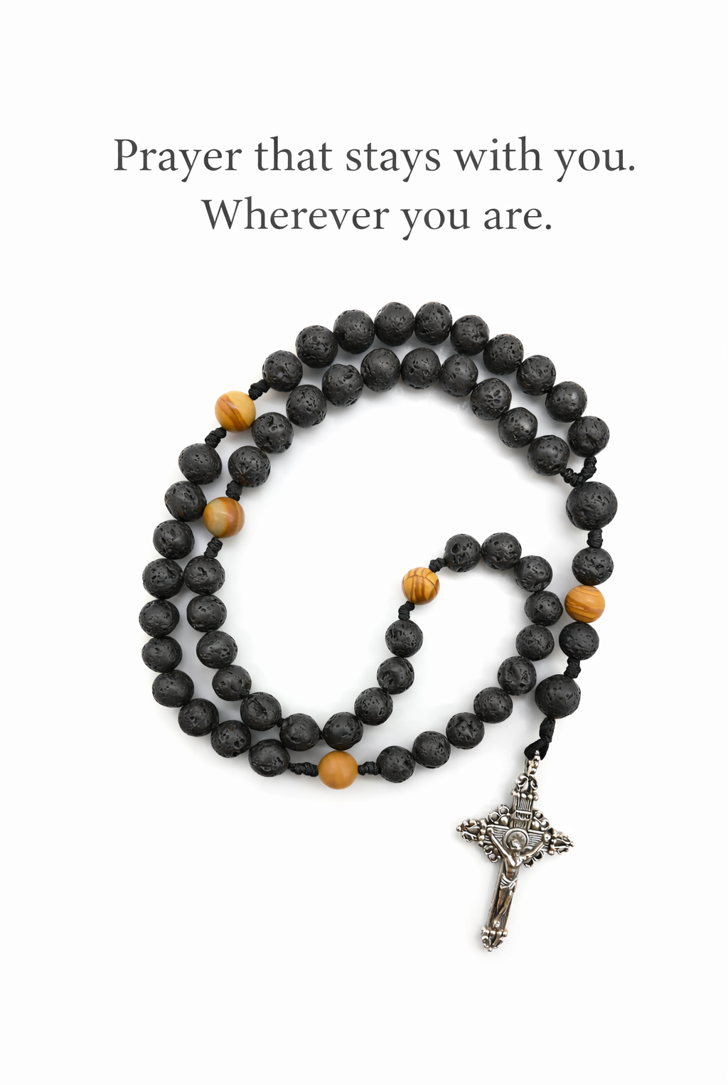 Catholic pocket rosary with black lava stone beads and silver crucifix on white background.