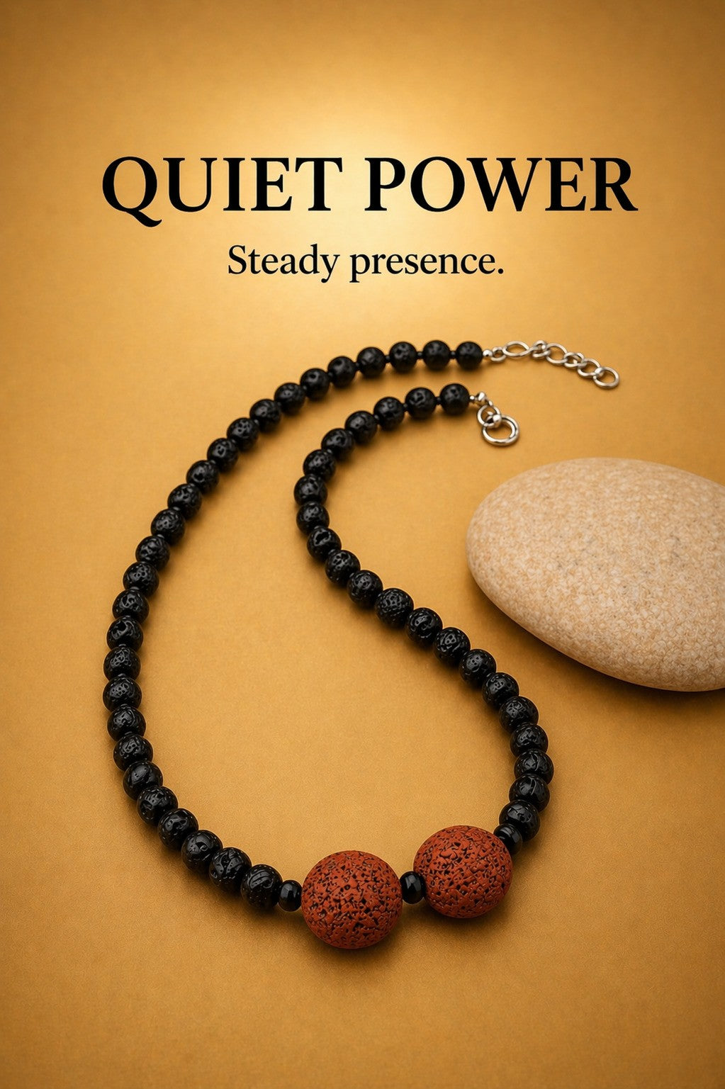 Black lava stone necklace with two red lava beads on warm brown background — QUIET POWER collection, “Steady presence.” by Polmadeva.