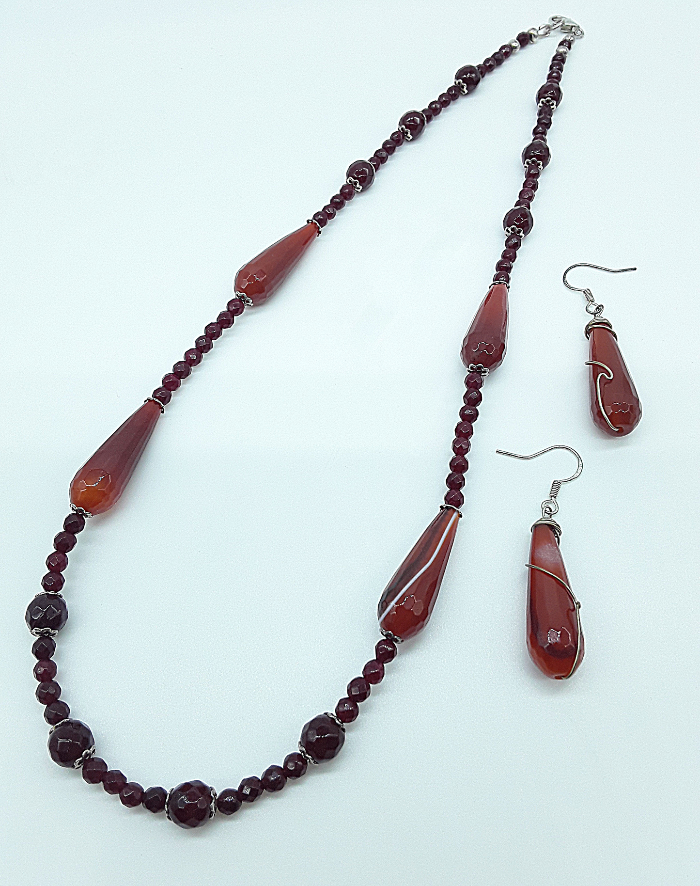Polmadeva handmade jewelry set with agate tear-drop stones and silver details on white background