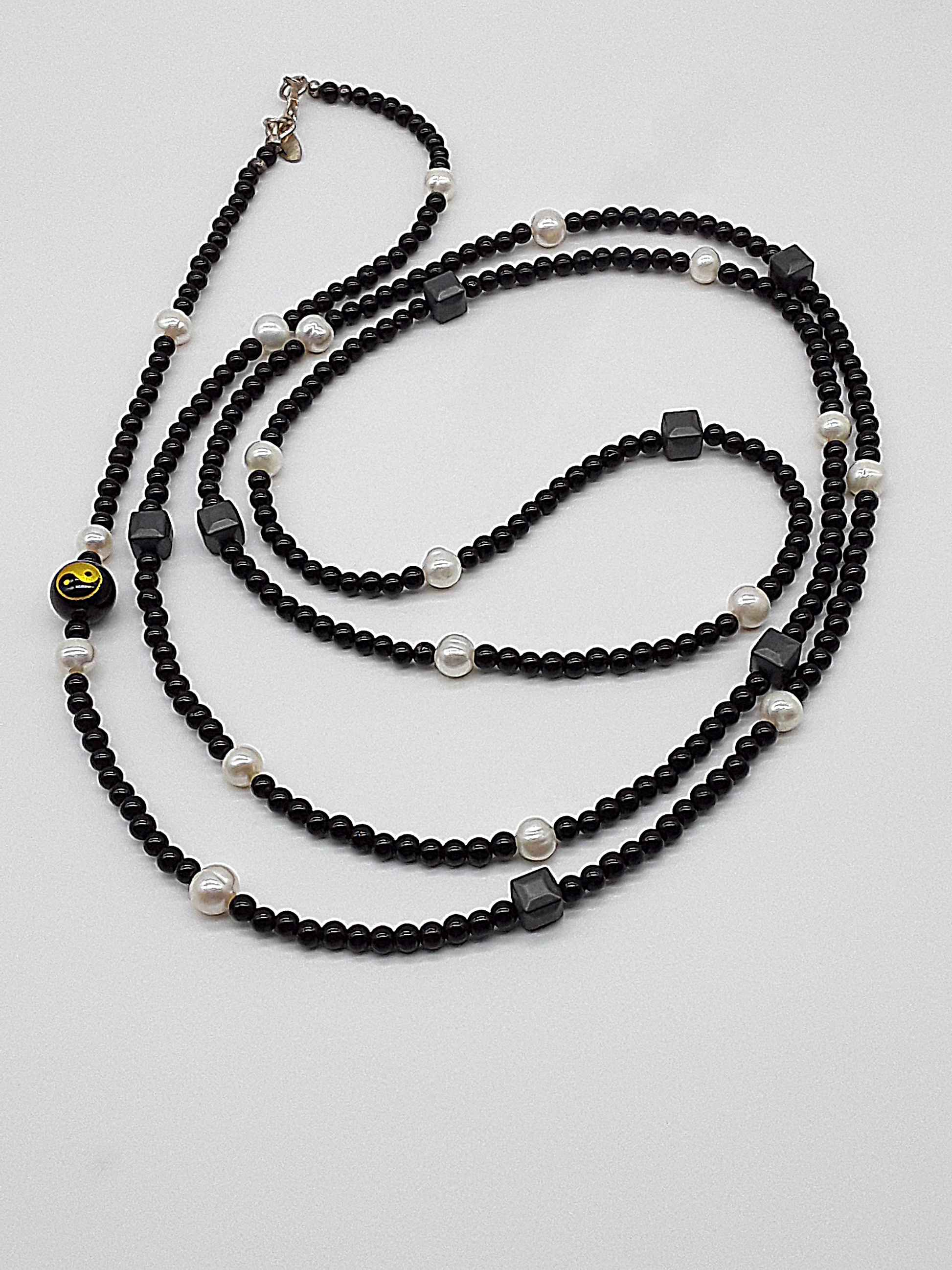 The Yin–Yang Guardian Necklace by Polmadeva – black onyx, hematite and freshwater pearl necklace with yin–yang bead symbolizing harmony, balance, and strength
