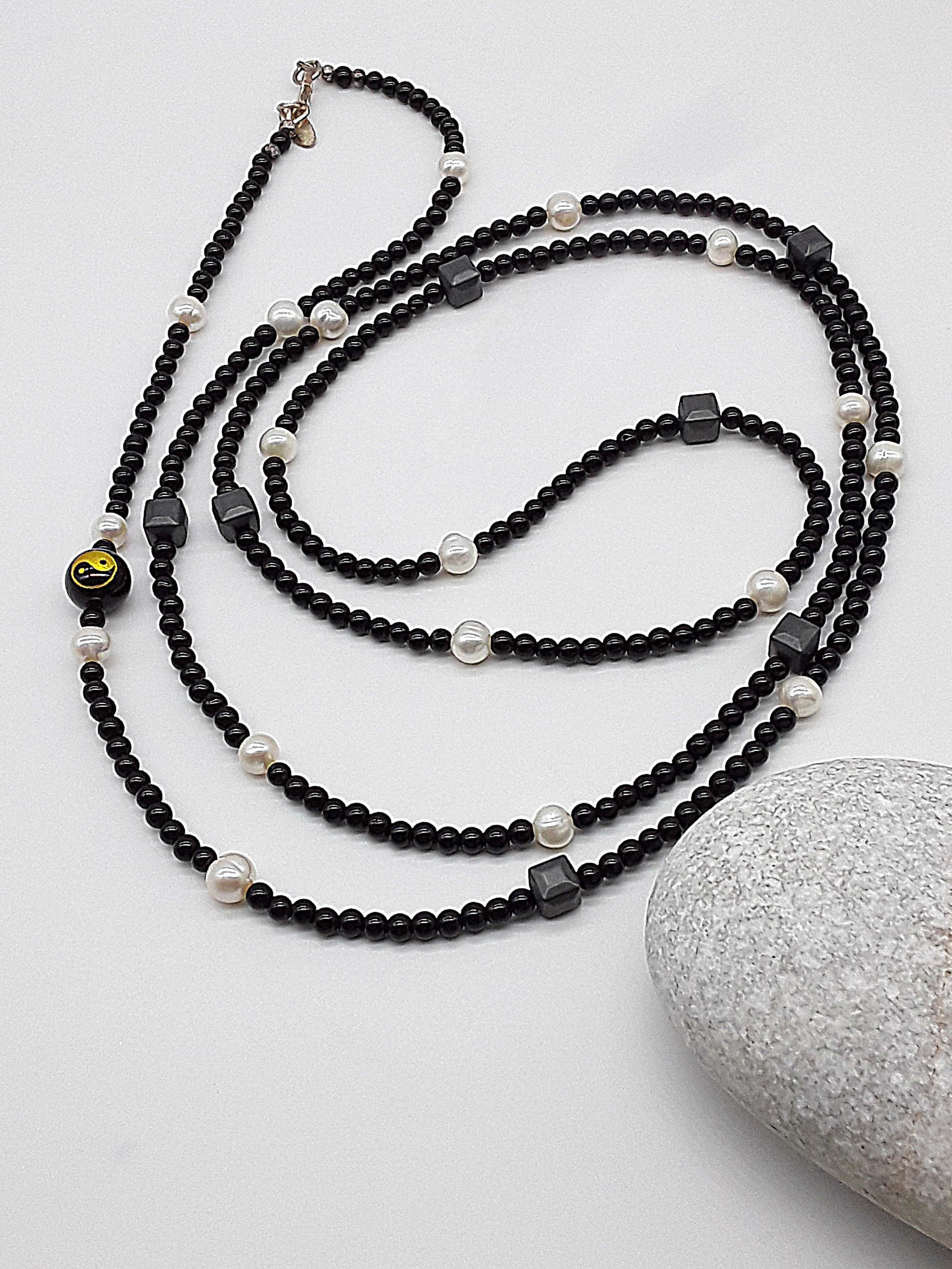 The Yin–Yang Guardian Necklace by Polmadeva – black onyx, hematite and freshwater pearl necklace with yin–yang bead symbolizing harmony, balance, and strength