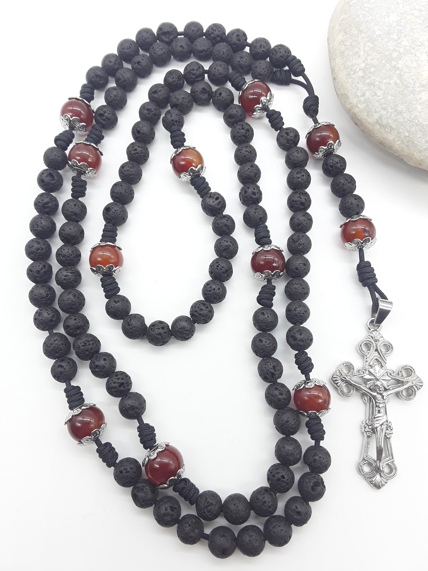 Carried Through Time lava stone and carnelian 10-decade Catholic rosary beside stone by Polmadeva
