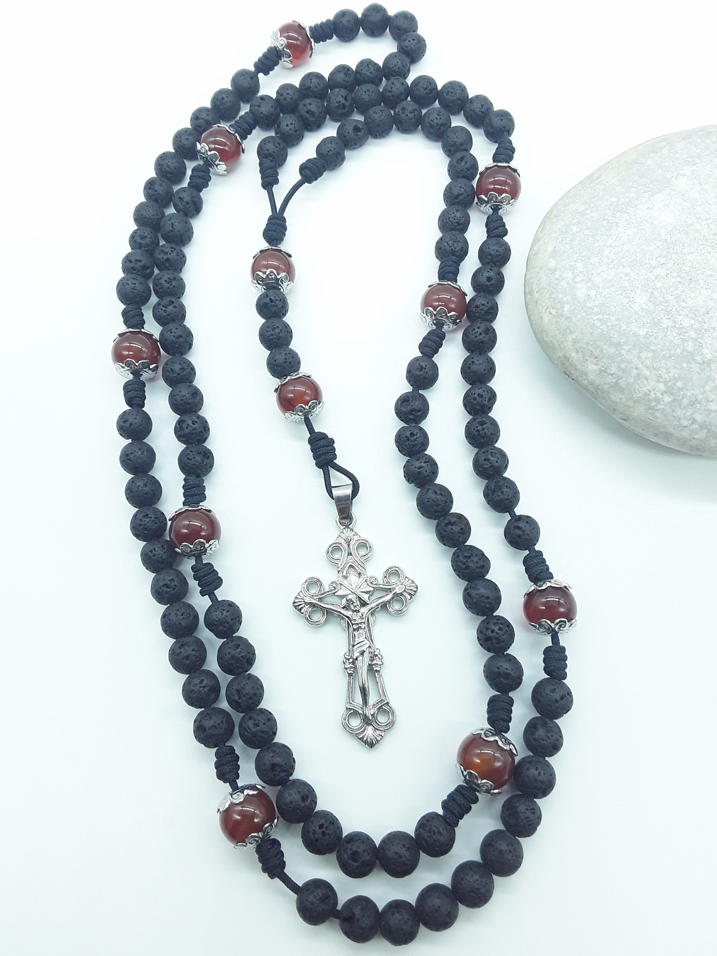 Carried Through Time lava stone and carnelian 10-decade Catholic rosary beside stone by Polmadeva