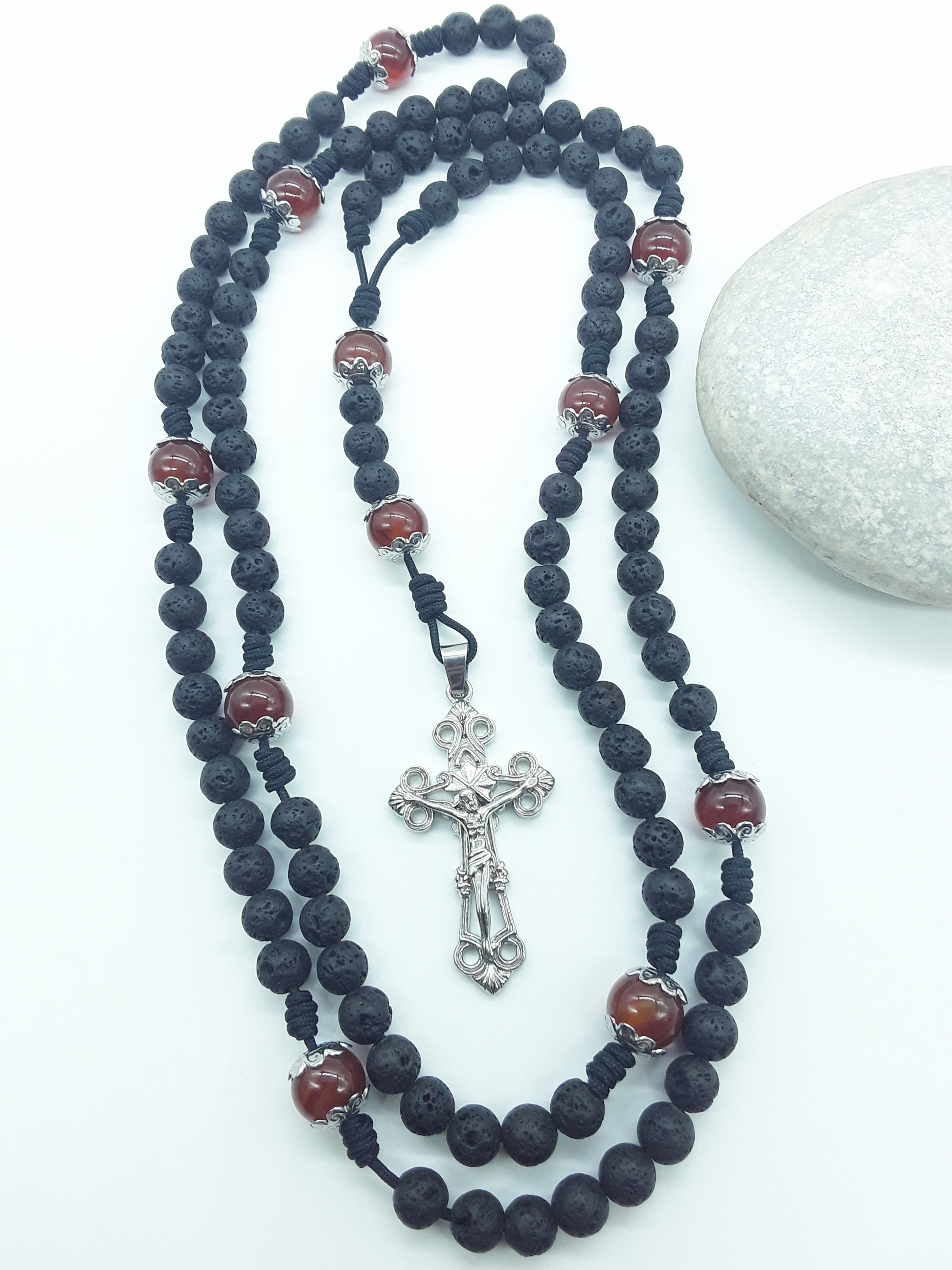 Carried Through Time lava stone and carnelian 10-decade Catholic rosary beside stone by Polmadeva