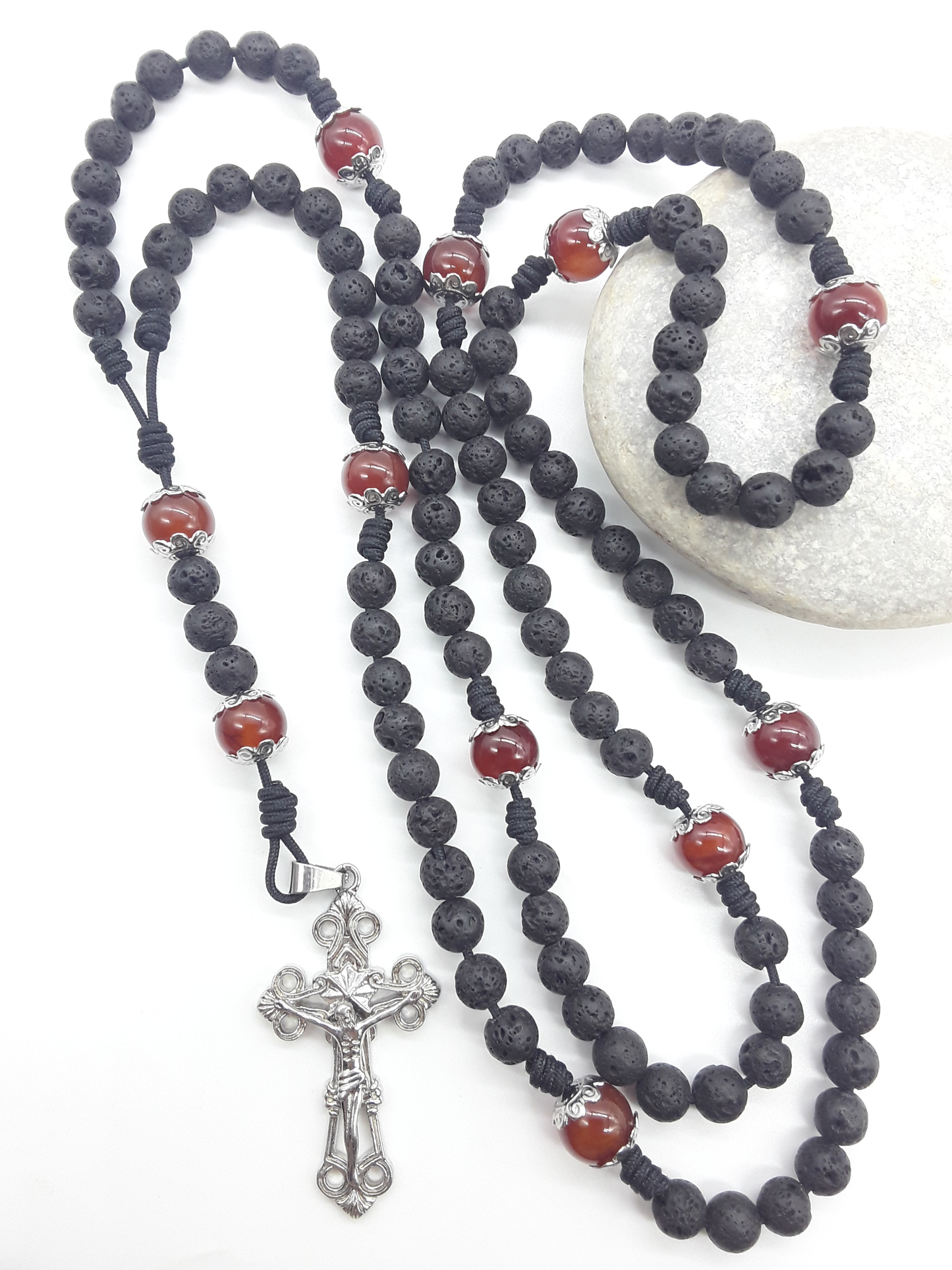 Carried Through Time lava stone and carnelian 10-decade Catholic rosary beside stone by Polmadeva
