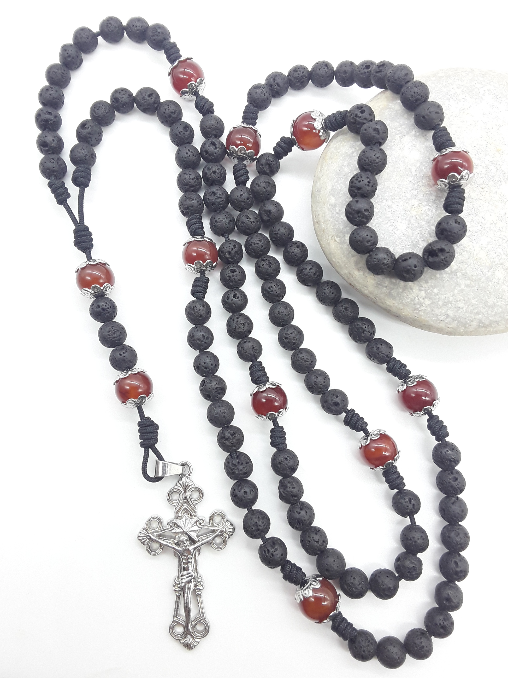 Carried Through Time lava stone and carnelian 10-decade Catholic rosary beside stone by Polmadeva
