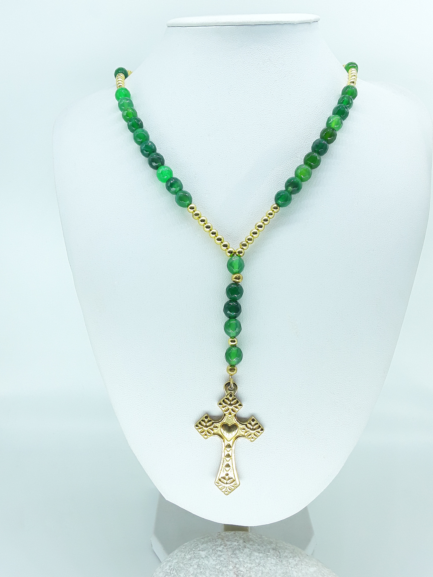 Traditional Catholic rosary made with natural green agate beads, hematite spacers, and a stainless steel heart-shaped cross, displayed on a white bust.
