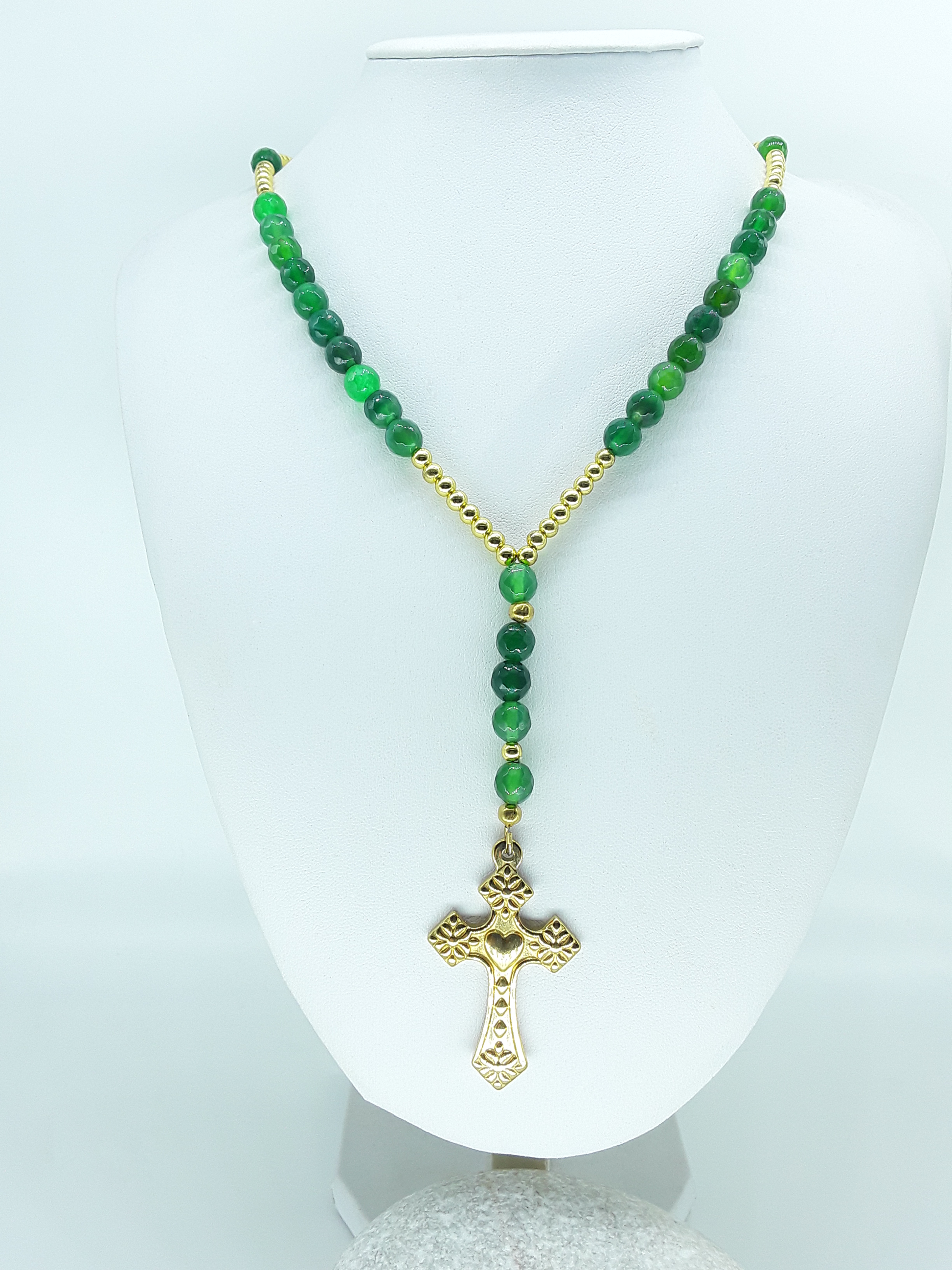 Traditional Catholic rosary made with natural green agate beads, hematite spacers, and a stainless steel heart-shaped cross, displayed on a white bust.
