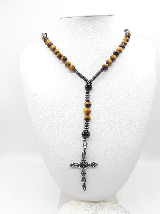 Traditional Catholic rosary made with tiger’s eye beads, black onyx, hematite spacers, and a stainless steel skull cross, displayed on a white bust.