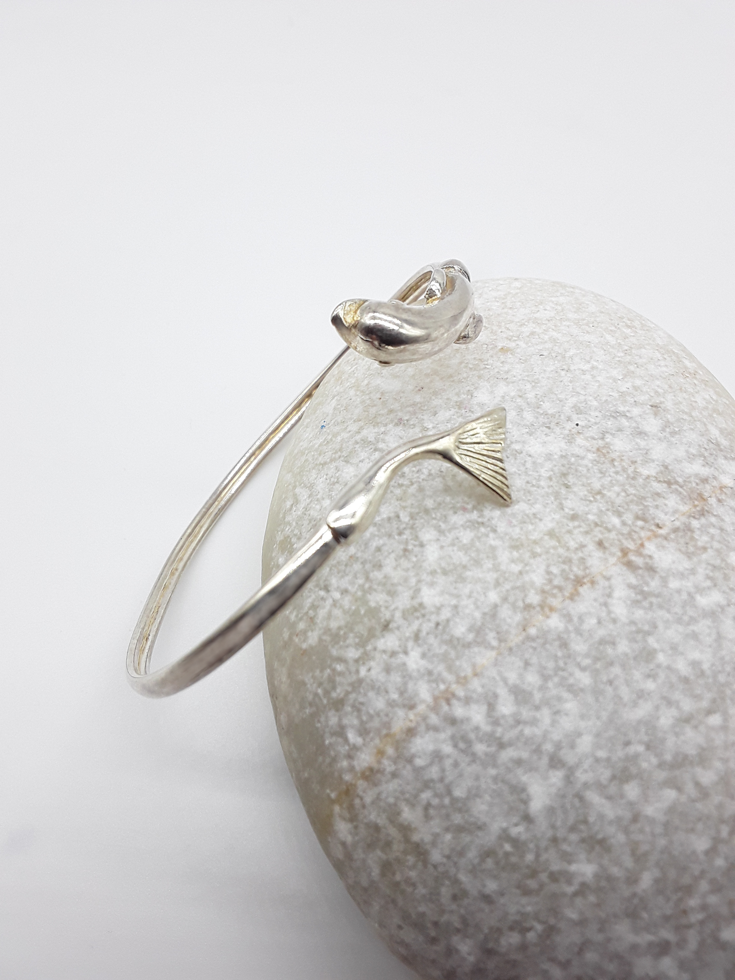 Sterling silver dolphin cuff bracelet on stone background — Polmadeva

