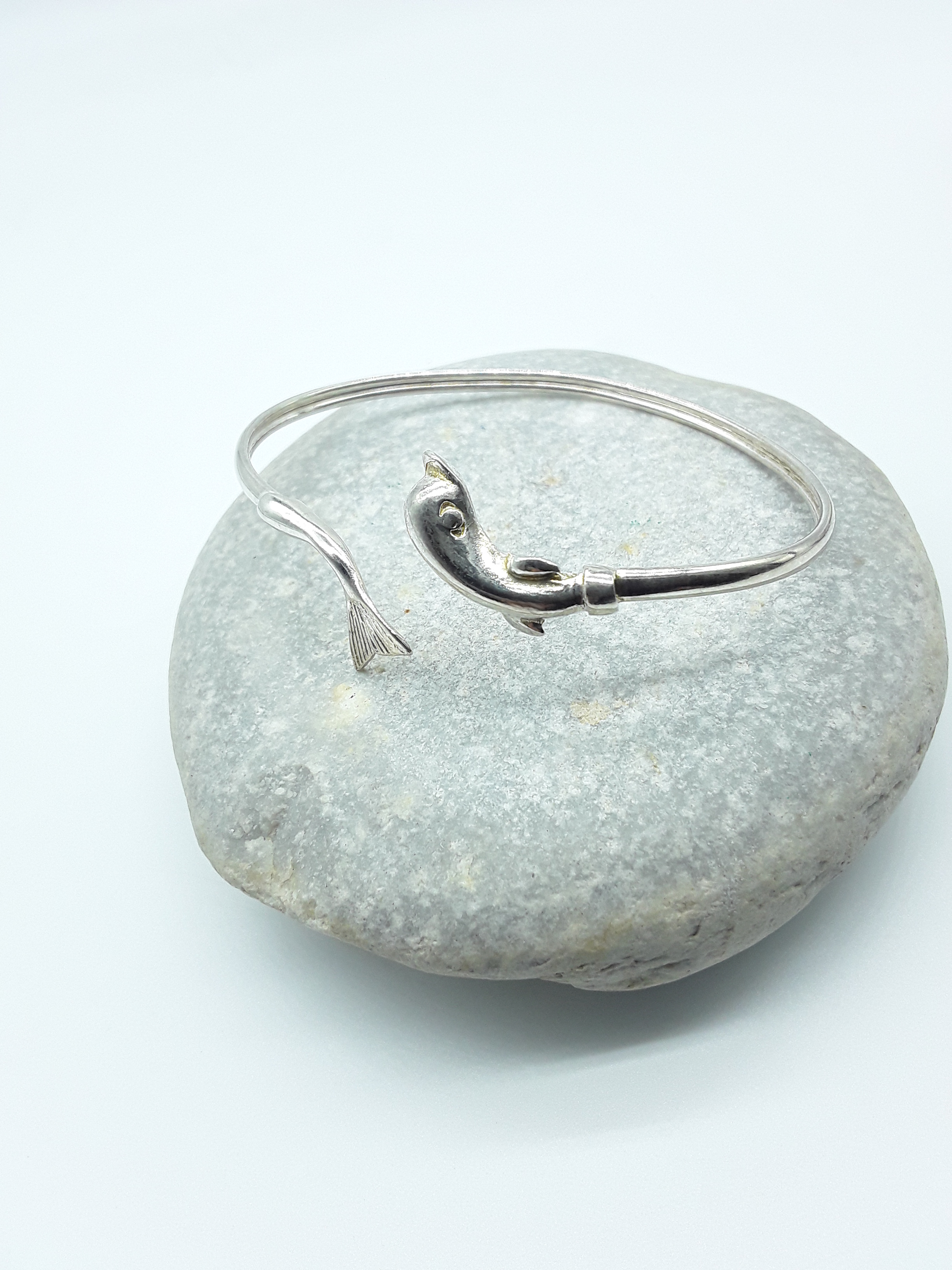 Silver dolphin bracelet photographed on natural stone — Polmadeva