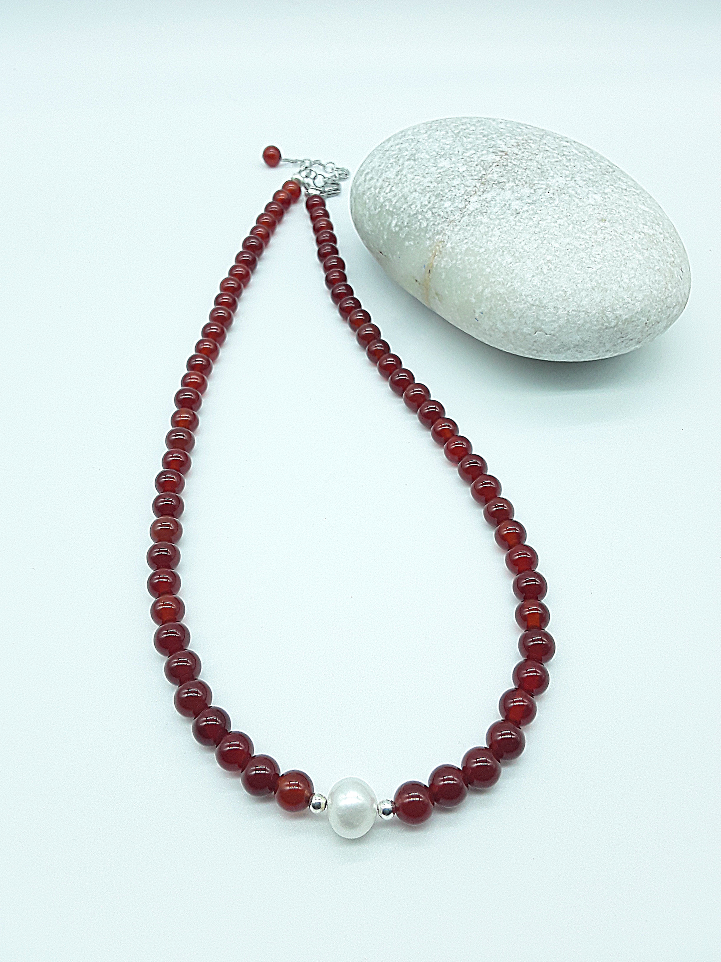 Heartfire Pearl Necklace by Polmadeva laid flat with red carnelian beads, freshwater pearl and silver clasp, Courage Rising collection