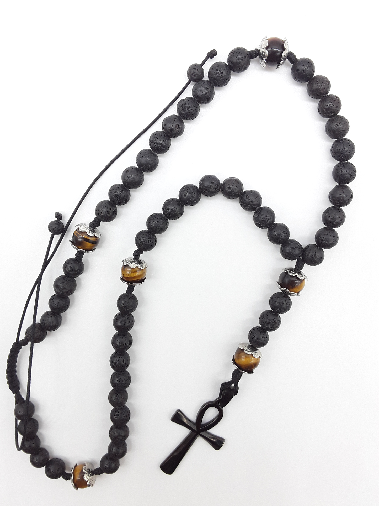 Held in Direction — Lava & Tiger’s Eye Ankh Catholic Rosary (5 Decade) by Polmadeva with black stainless steel Ankh cross on white background.