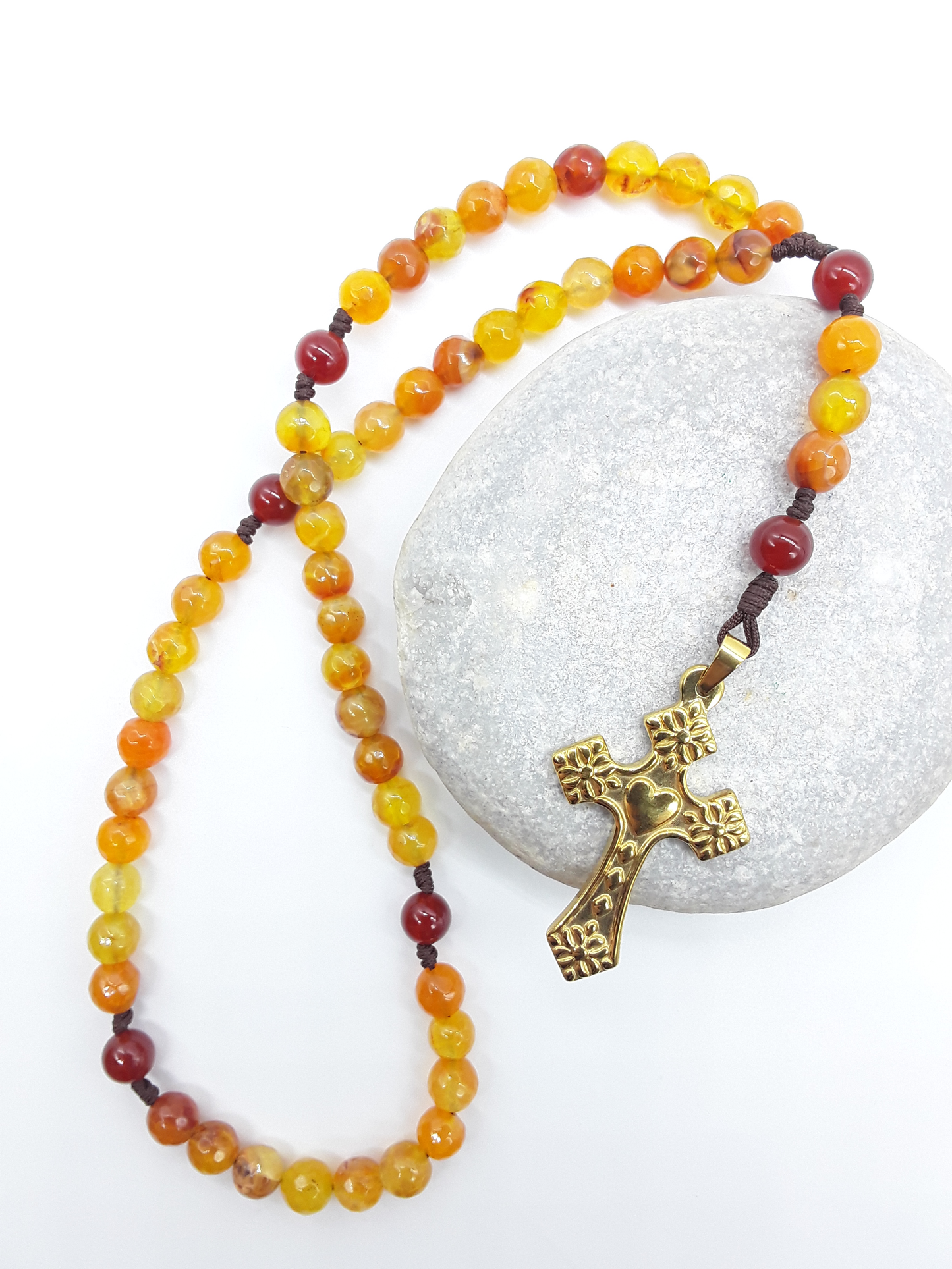 Handcrafted Agate and Carnelian pocket rosary resting on stone surface with heart-shaped cross