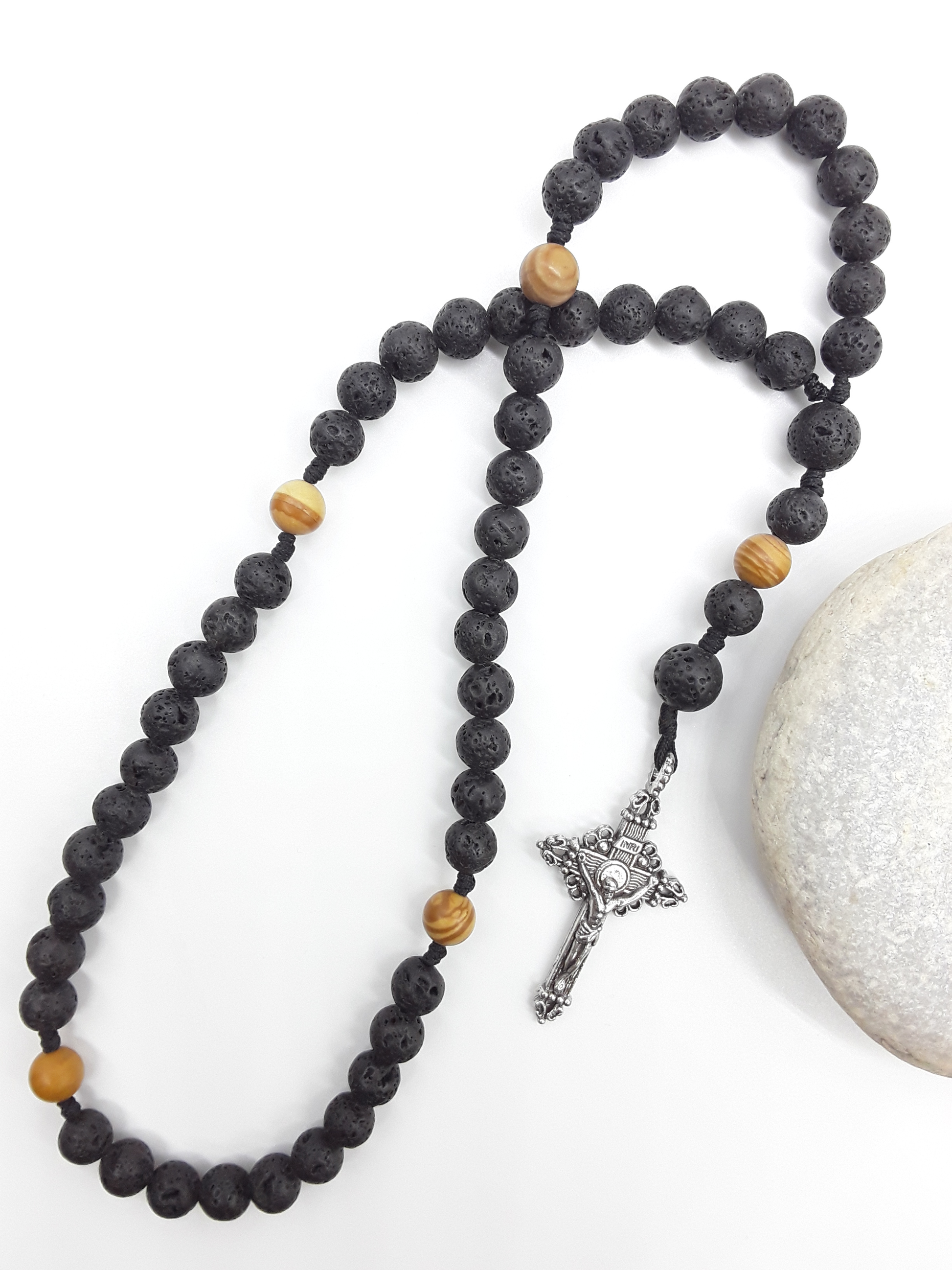 Handcrafted Pocket & Travel Catholic Rosary in lava and tigerskin jasper resting beside a natural stone, with a detailed tin crucifix.