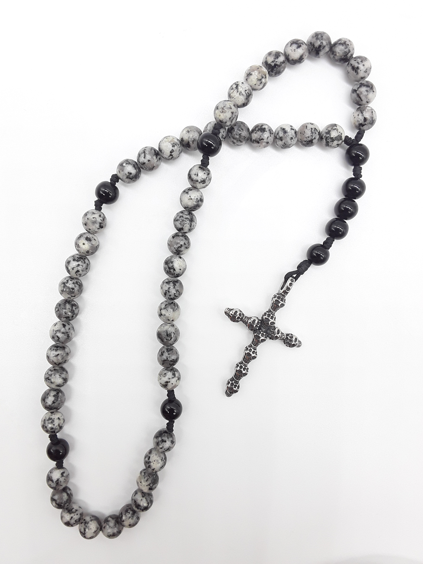 Pocket Catholic Rosary with jasper and black onyx beads and textured stainless steel cross on white background.