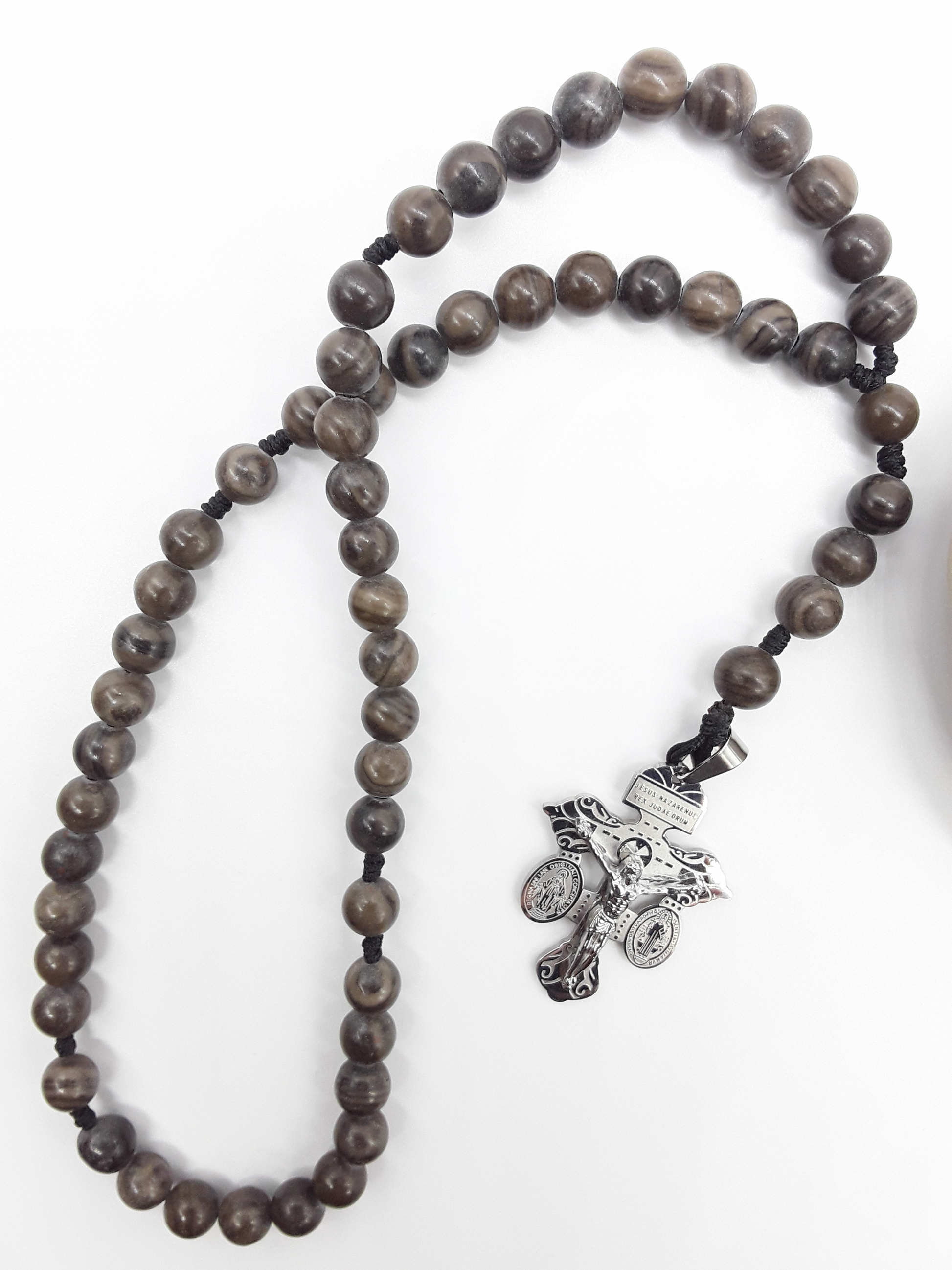 Pocket Catholic rosary crafted with Black Wood Lace Stone beads and a stainless steel crucifix, arranged on a white background.