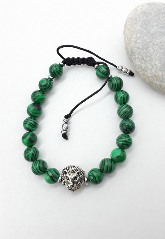 Lion bracelet with malachite beads placed beside natural stone