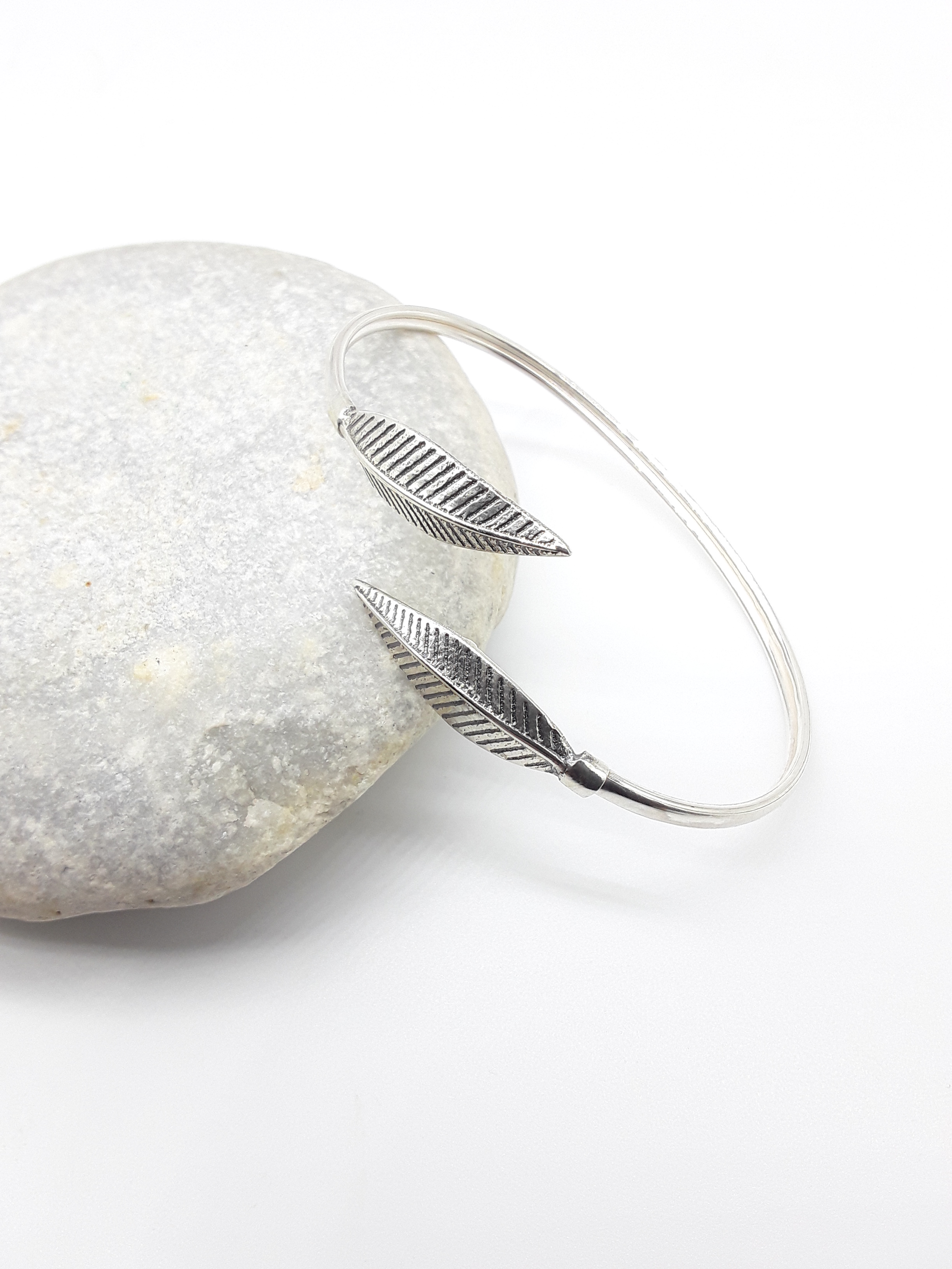 Leaf Form sterling silver cuff bracelet beside stone — Polmadeva