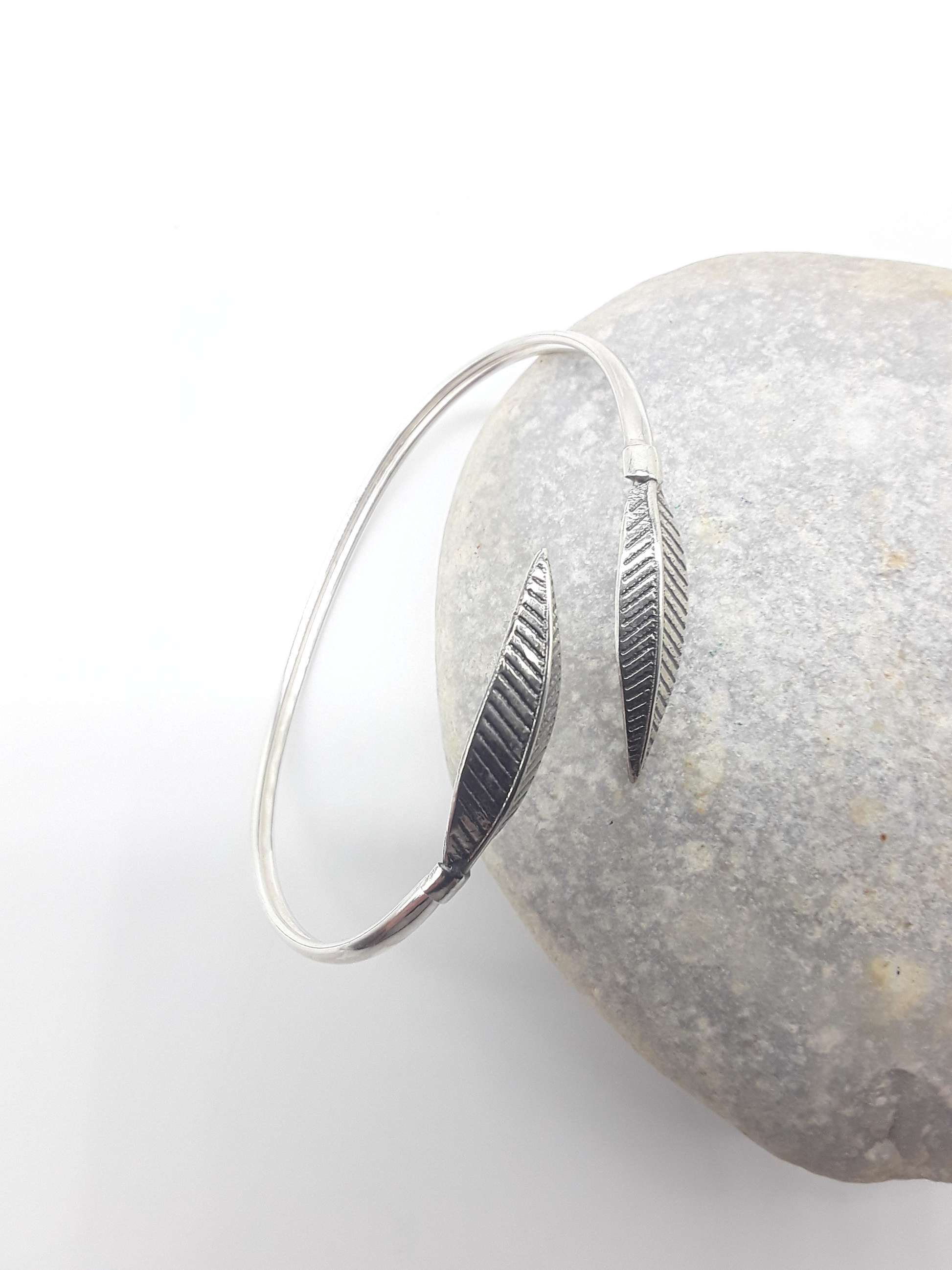 Leaf Form sterling silver cuff bracelet beside stone — Polmadeva
