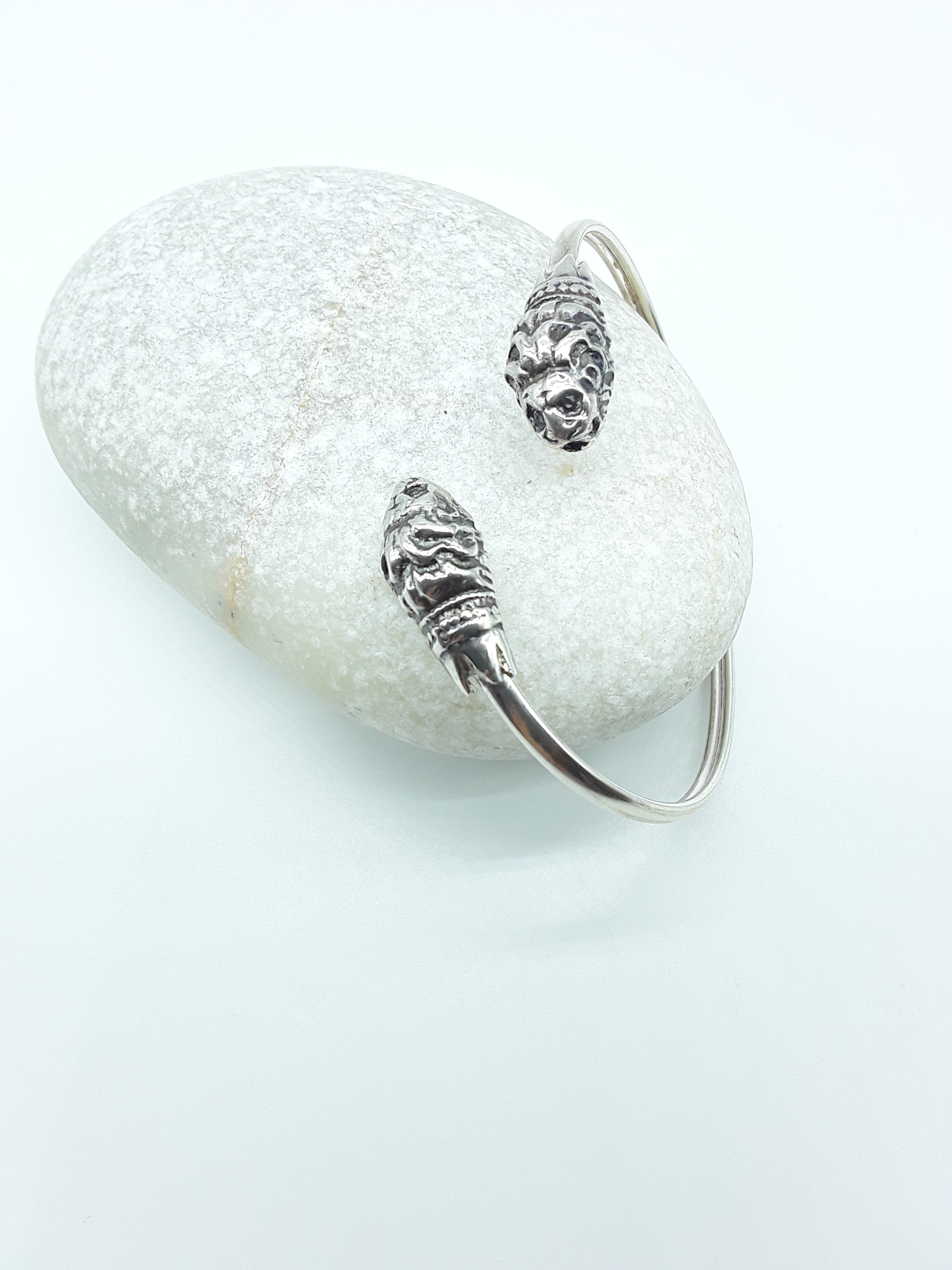 Lion Presence sterling silver cuff bracelet beside stone — Polmadeva