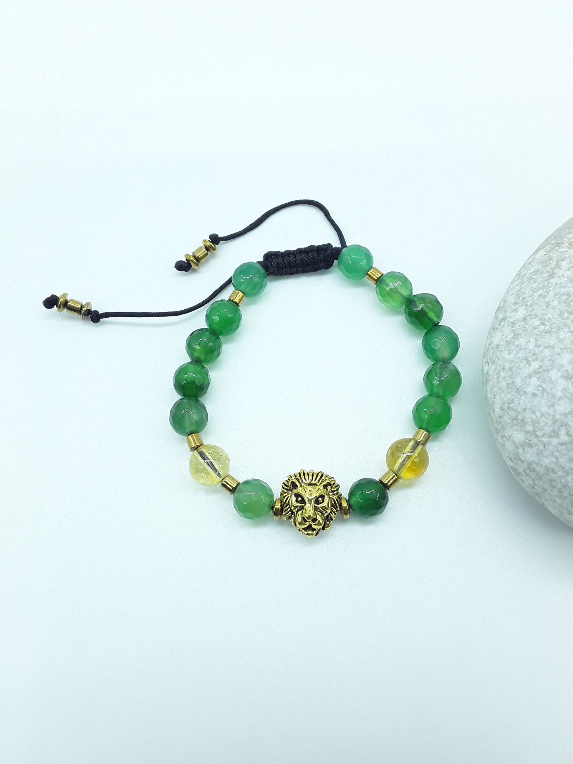 Quiet Ascent Lion Bracelet by Polmadeva placed beside a natural stone, featuring citrine, agate and a lion element