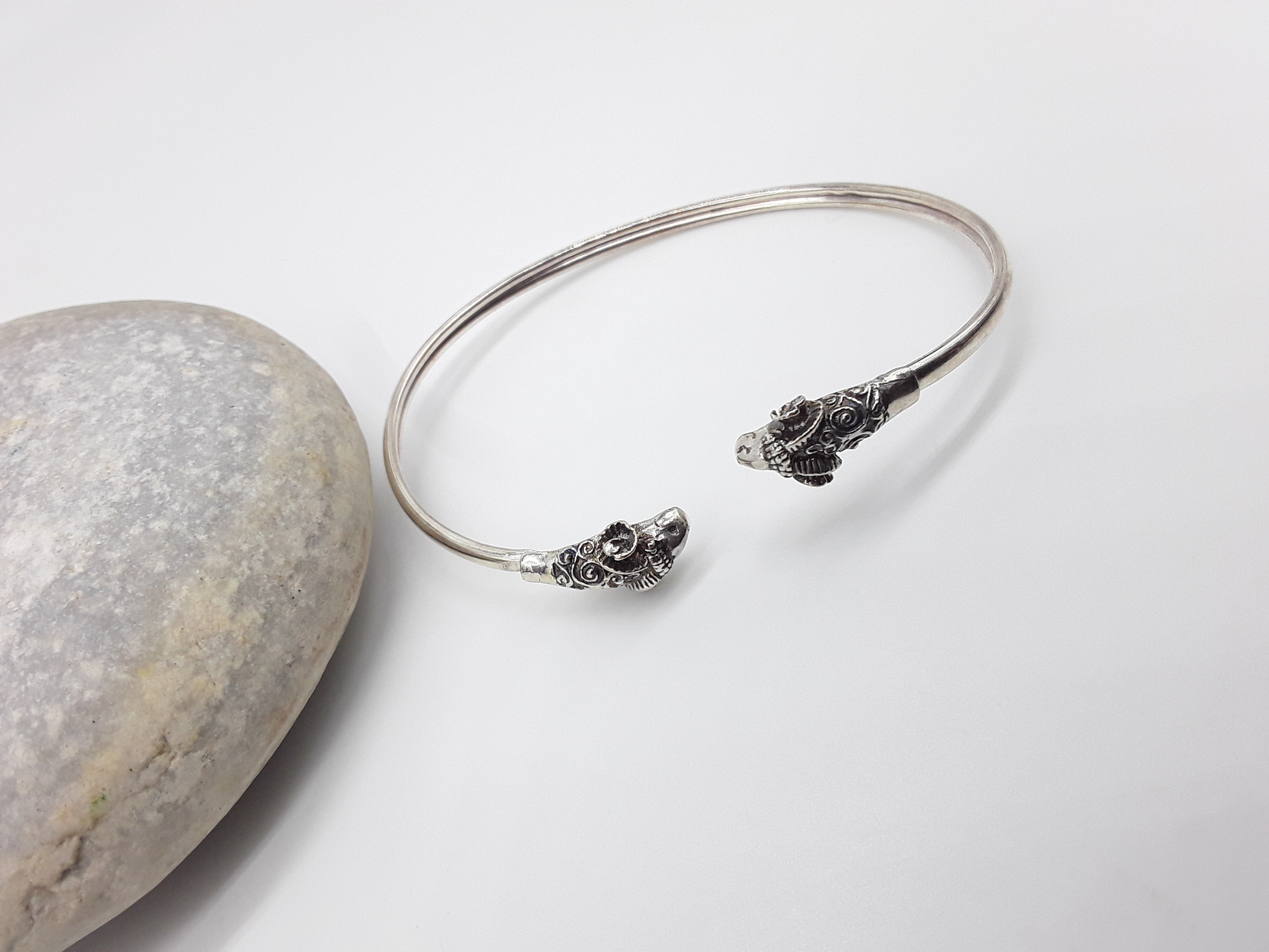 Ram Presence sterling silver cuff bracelet beside stone — Polmadeva