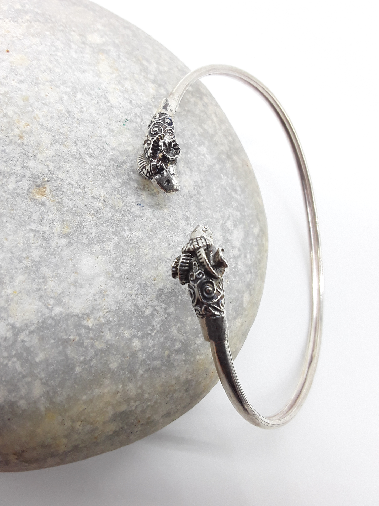 Ram Presence sterling silver cuff bracelet beside stone — Polmadeva