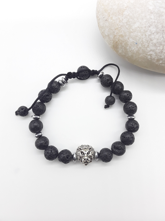 Lava stone lion bracelet beside natural stone, highlighting balance, resilience, and quiet authority