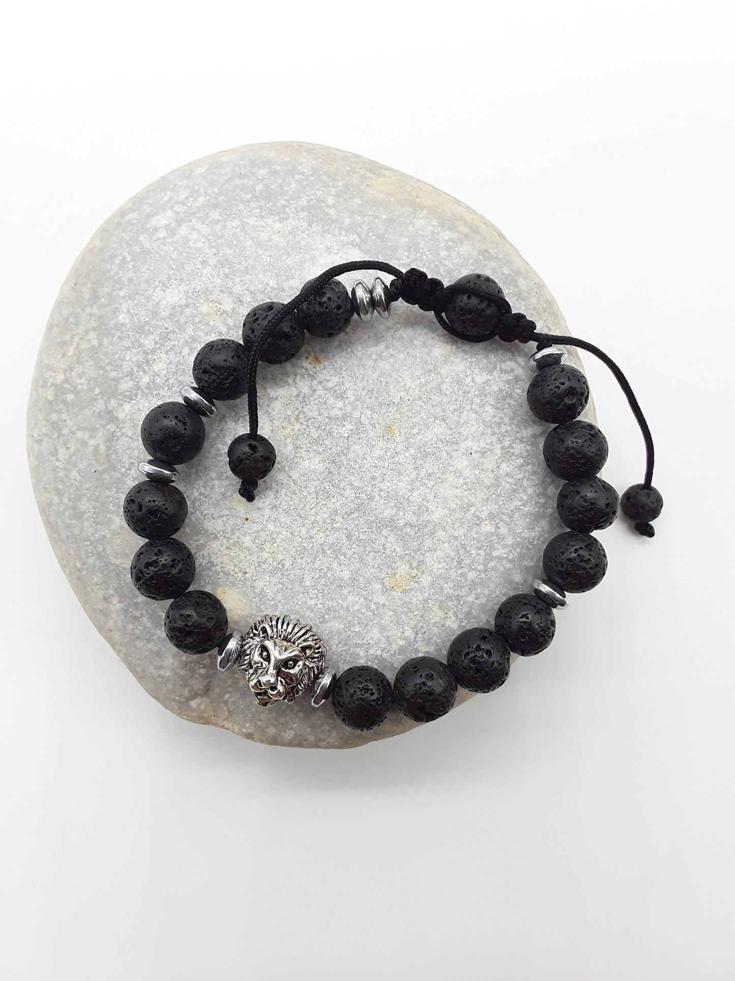 Lava stone lion bracelet placed on a natural stone, symbolizing grounded strength and calm power