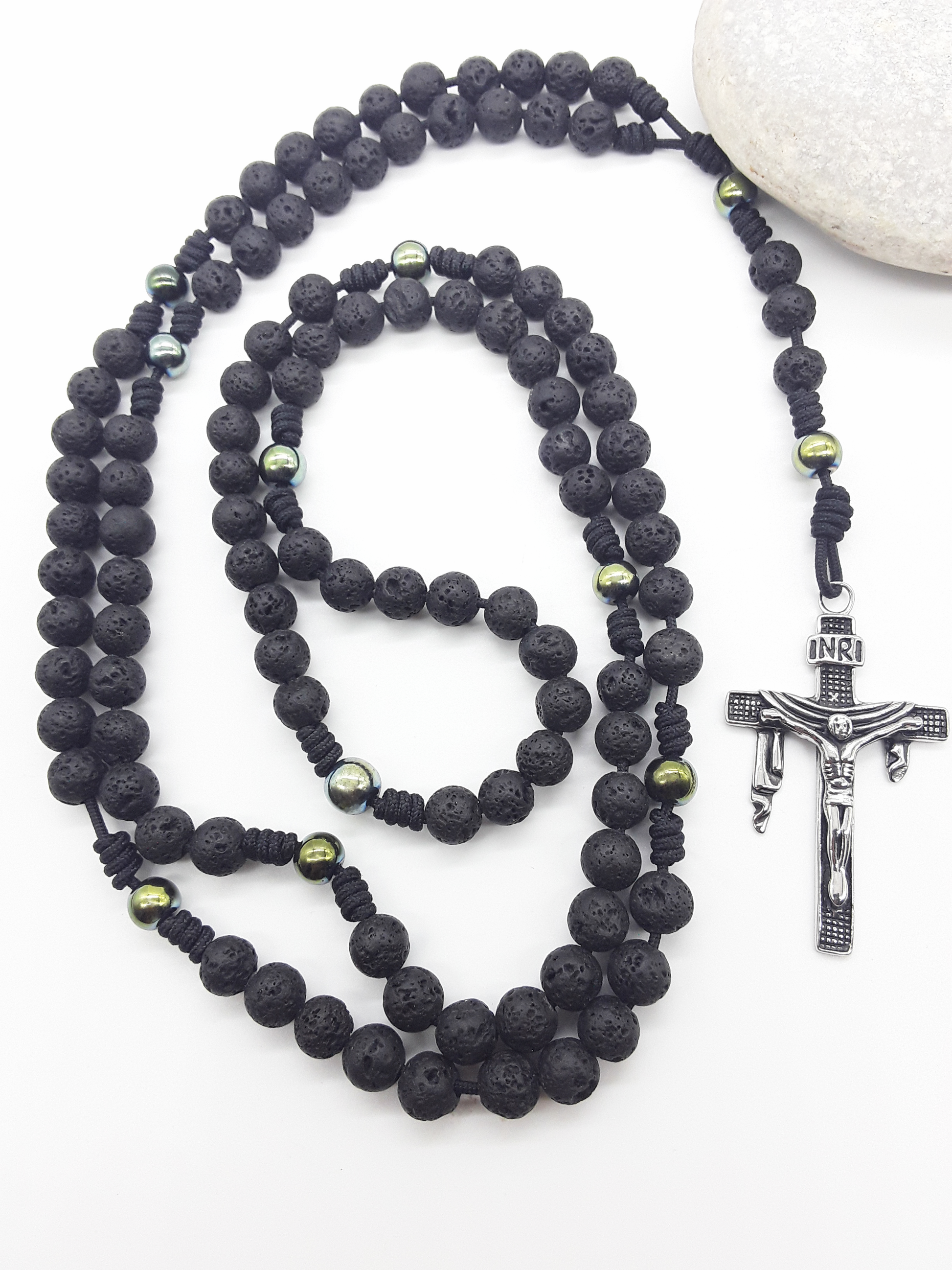 Steadfast Path lava stone and hematite 10-decade Catholic rosary with stainless steel crucifix beside stone by Polmadeva